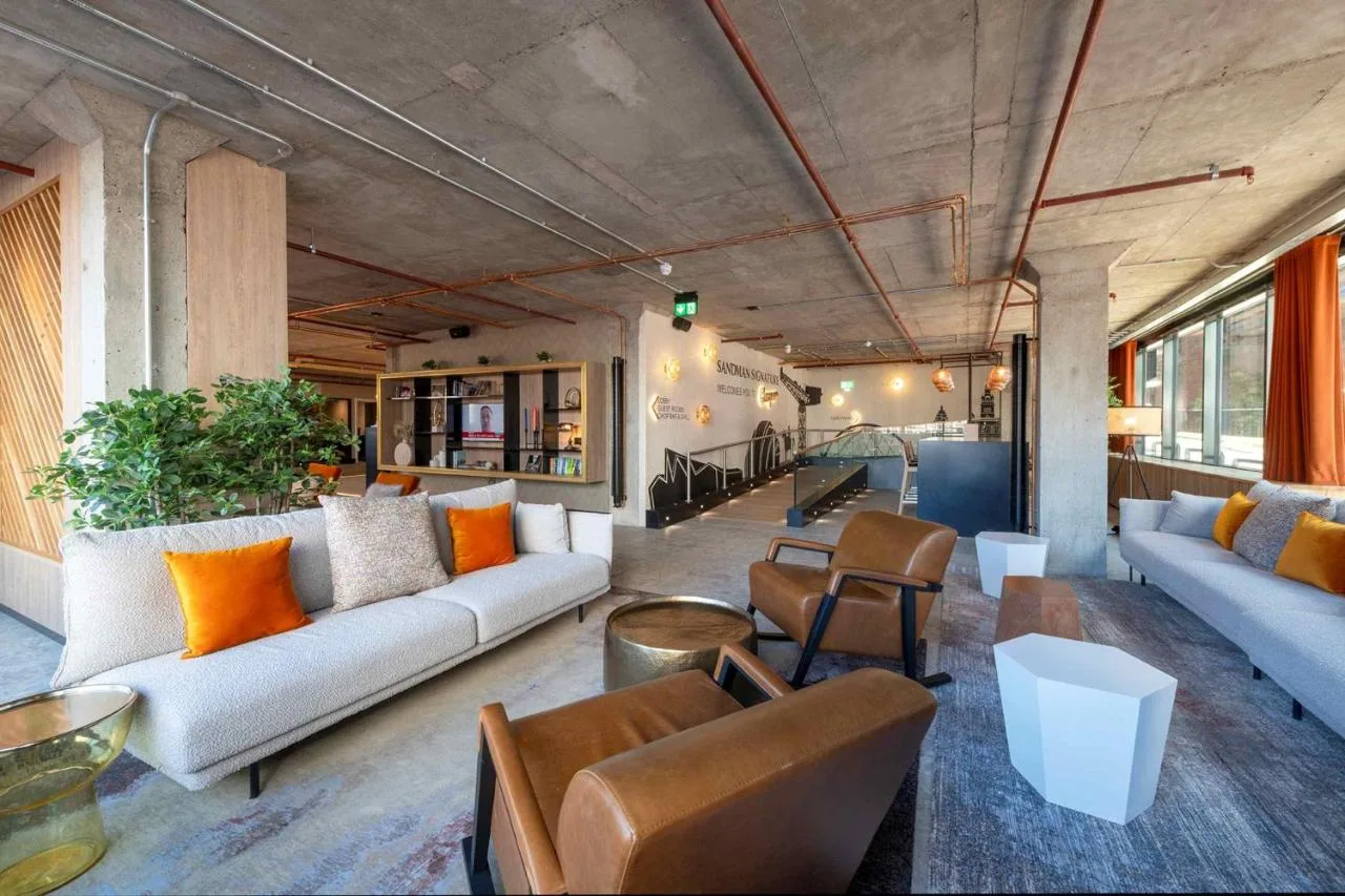 a living room with couches and chairs at Sandman Signature Glasgow Hotel in Glasgow