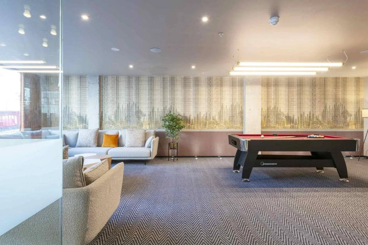 a living room with a pool table in a room at Sandman Signature Glasgow Hotel in Glasgow