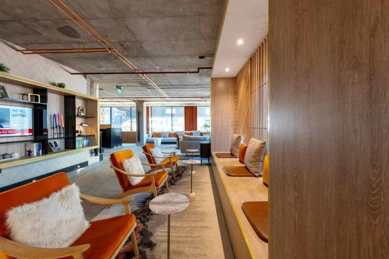 a lobby with chairs and tables and a waiting room at Sandman Signature Glasgow Hotel in Glasgow