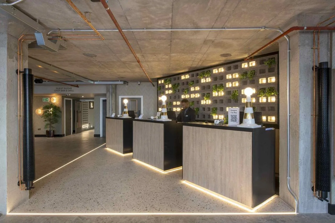 a lobby with a bar with a building in the background at Sandman Signature Glasgow Hotel in Glasgow