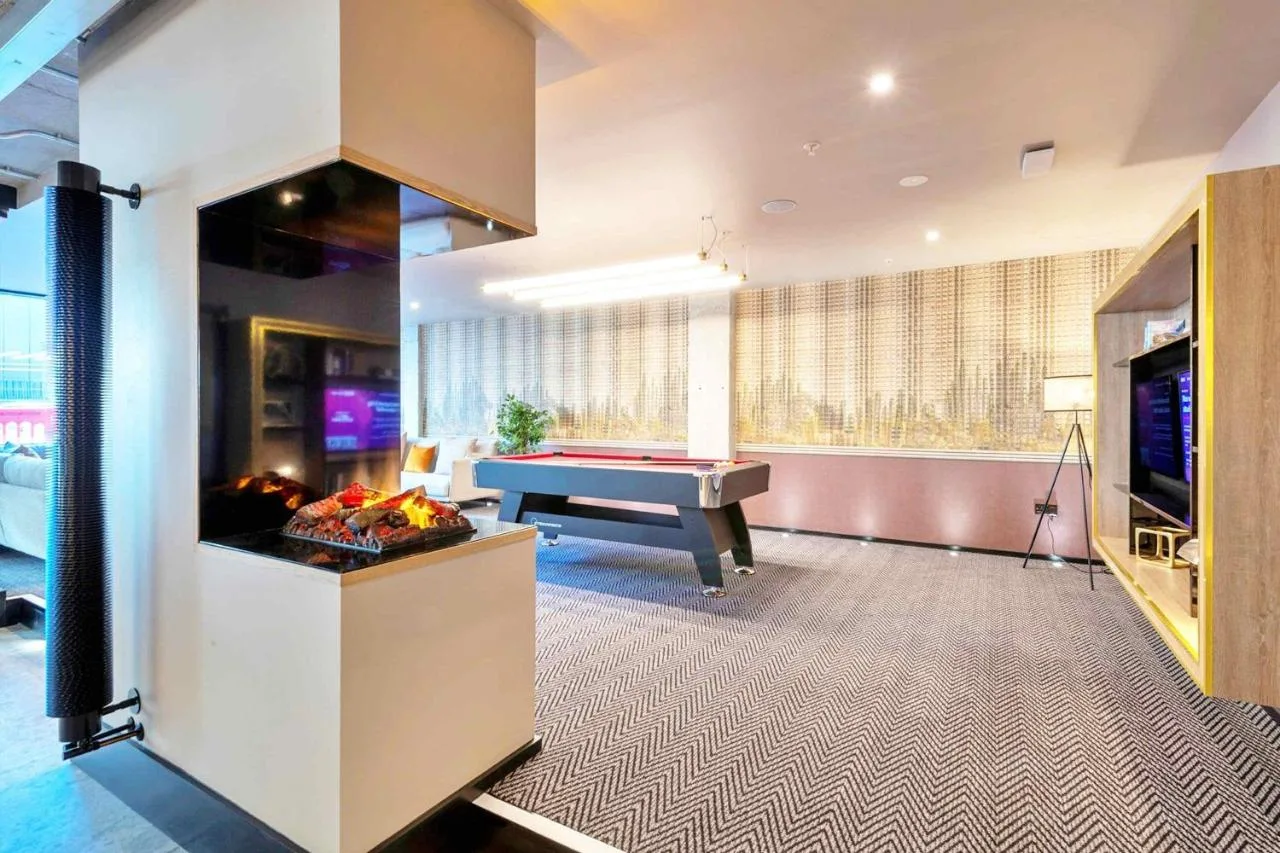 a living room with a pool table and a tv at Sandman Signature Glasgow Hotel in Glasgow