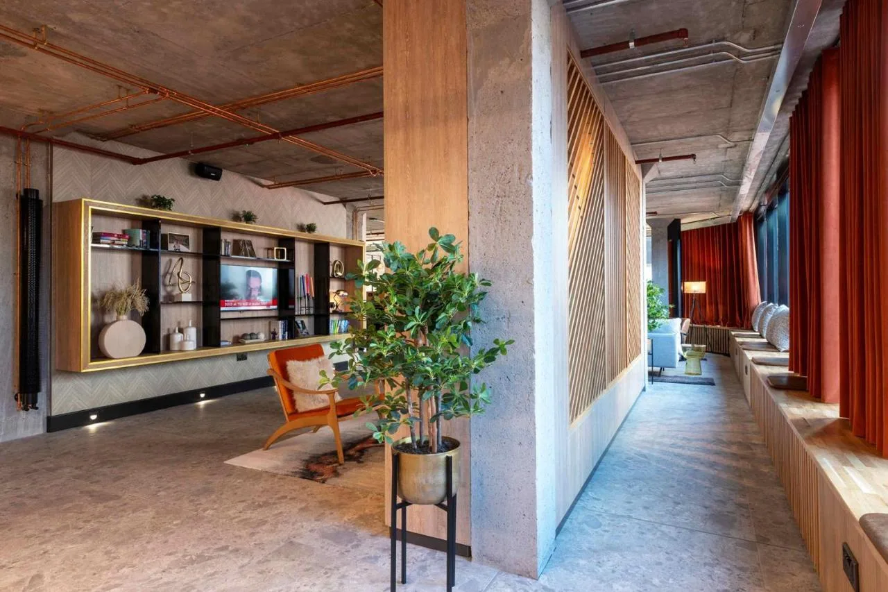 a living room with a potted plant in a building at Sandman Signature Glasgow Hotel in Glasgow